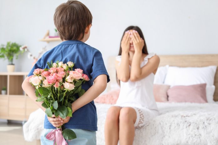 Child surprising mum with flowers on Mother's Day